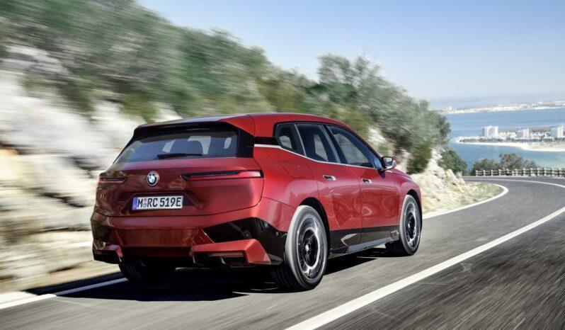 Luxusní elektrické SUV BMW iX xDrive50 zaparkované u moderní vily